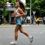Woman running outdoors wearing a grey LUMEFIT running vest